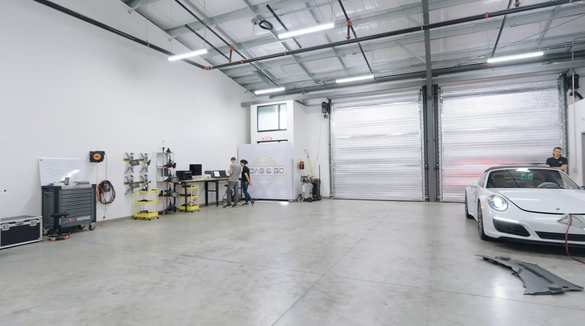 The equipment floor of the laboratory, with a white sports car parked at the far end.