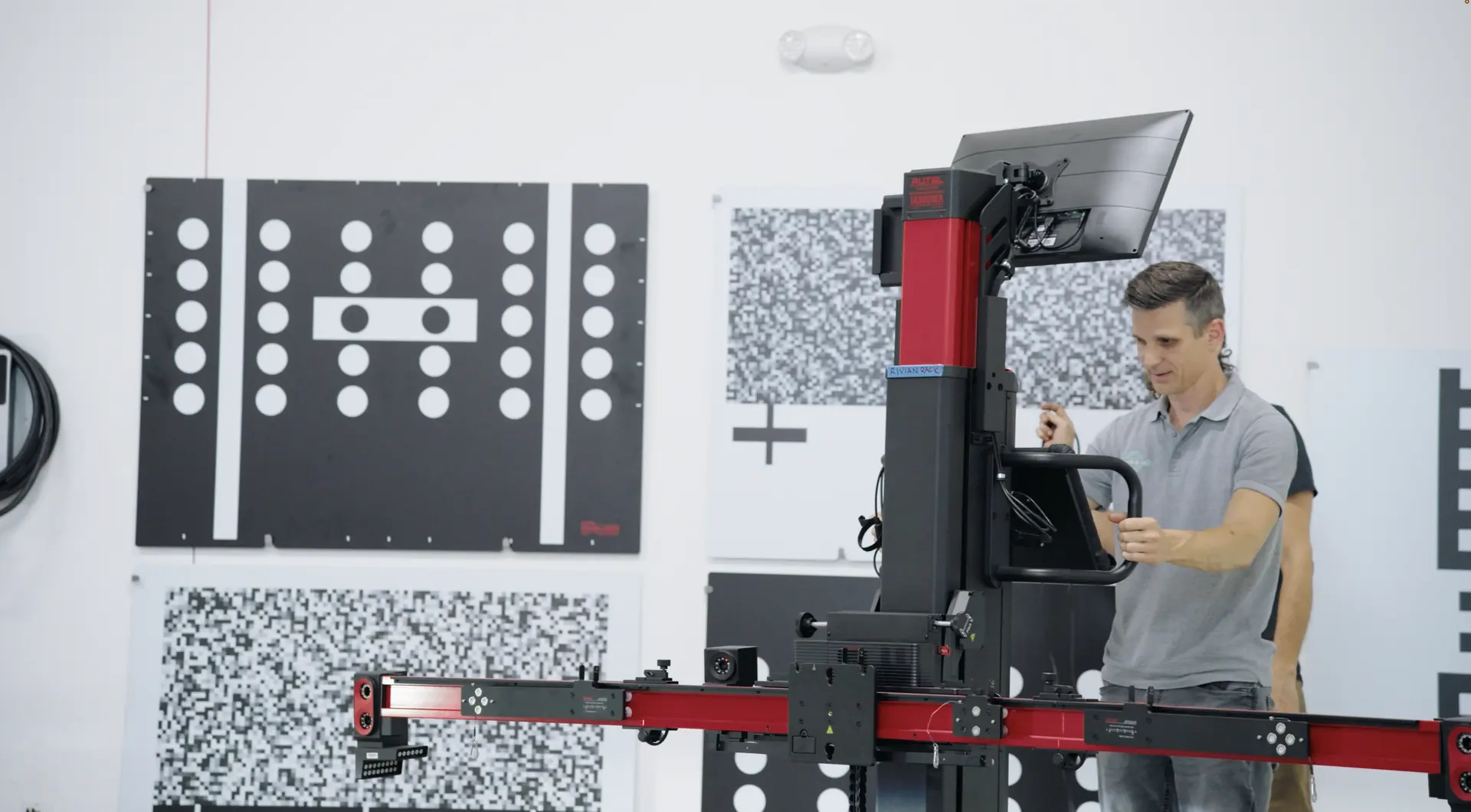A technician setting a calibration rig in front of a wall of pattern target boards.